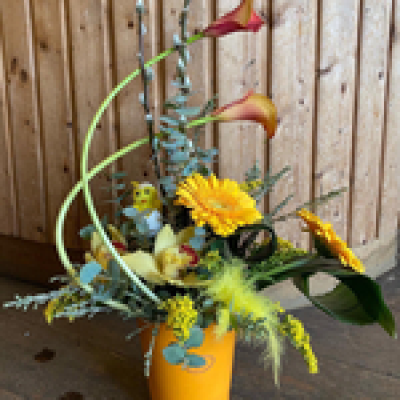 Spring Joy - This beautiful design is a tall front facing modern arrangement with choice flowers including calla lilies, Roses or Orchids and choice greenery. Arranged in oasis.