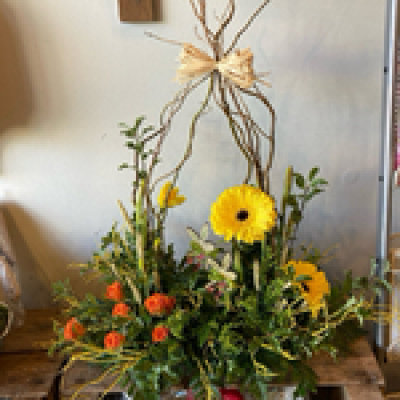 Spring into Easter - Flowers arranged in oasis for a front facing Spring display. Including twigs and picks to complete the look